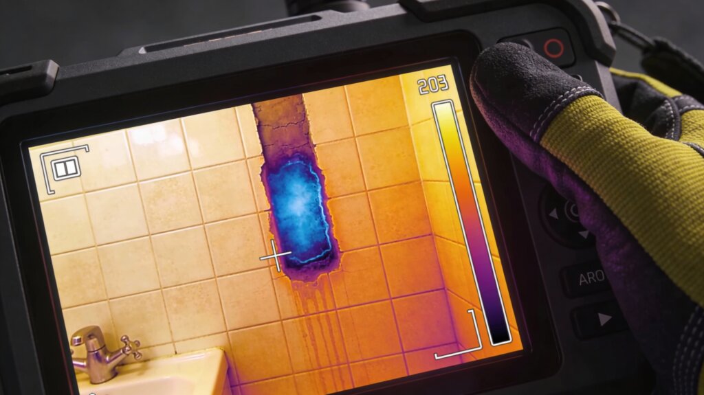 لقطة شاشة لكاميرا حرارية تظهر بقع تسرب المياه باللون الأزرق البارد خلف الحوائط الخرسانية في فيلا بجدة.